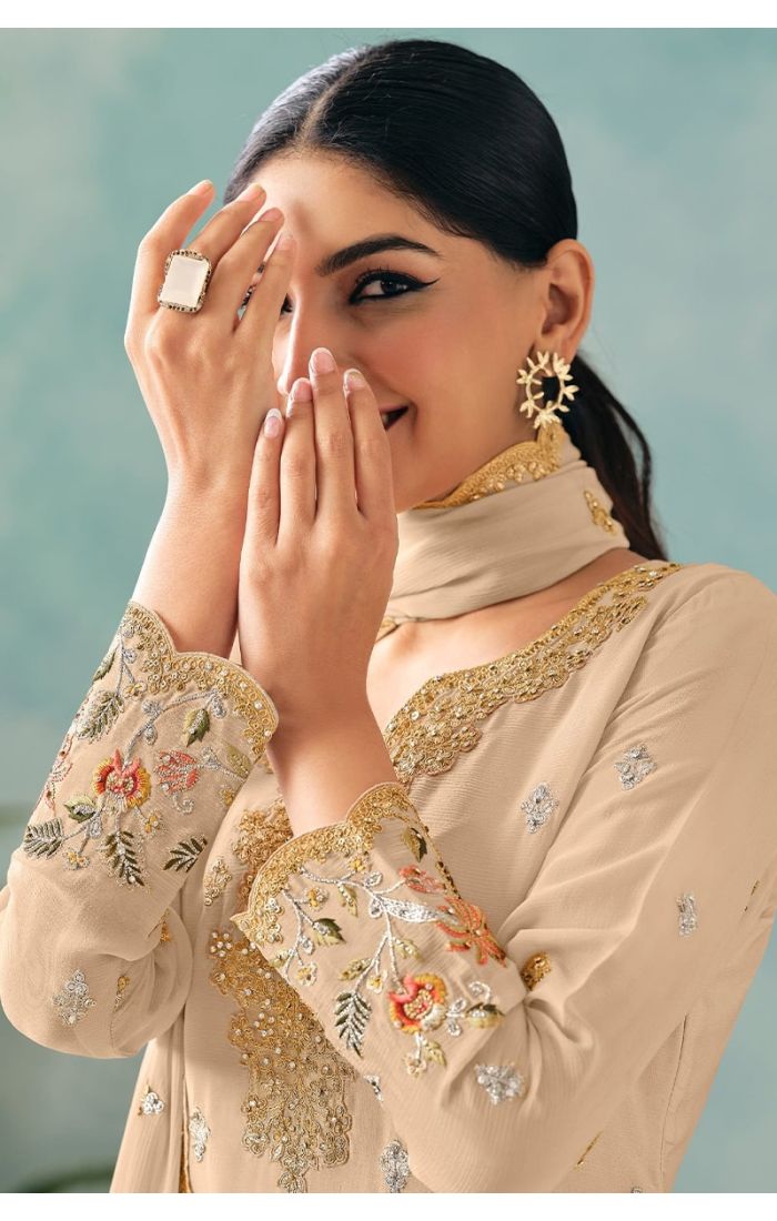 Close-up of neckline showing intricate thread embroidery and sequin detailing on cream chinon fabric.