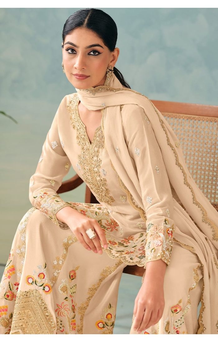  Sitting Front view of cream chinon salwar suit with heavy embroidery and sequins work paired with a matching dupatta.