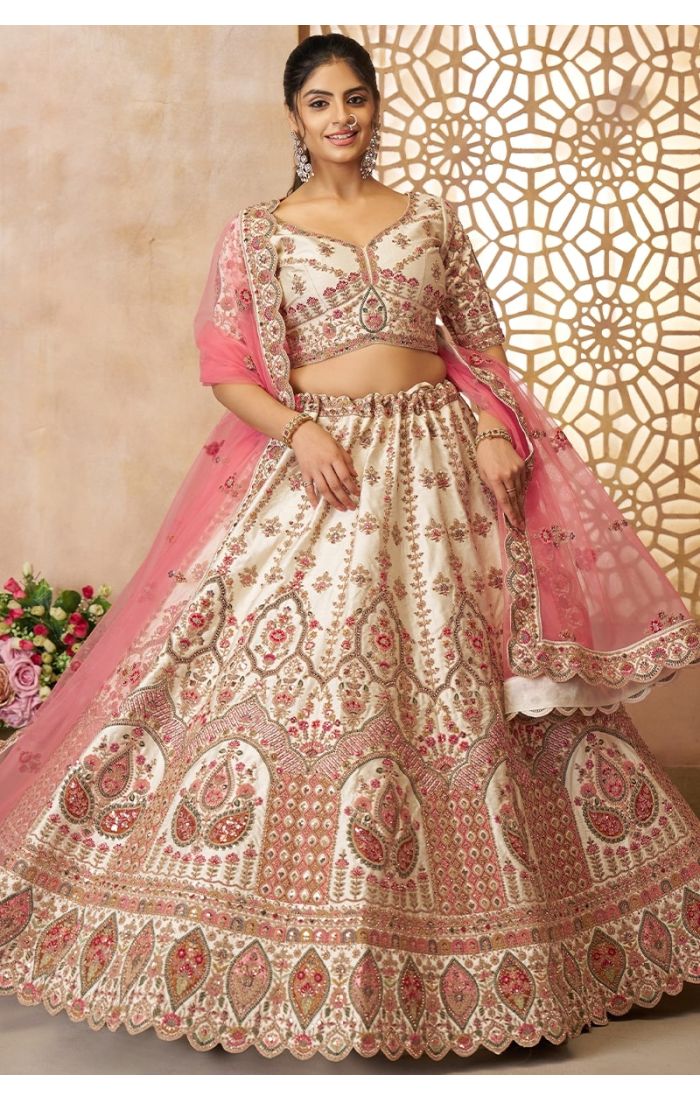 Bride wearing soft net pink dupatta over white bridal lehenga with heavy border
