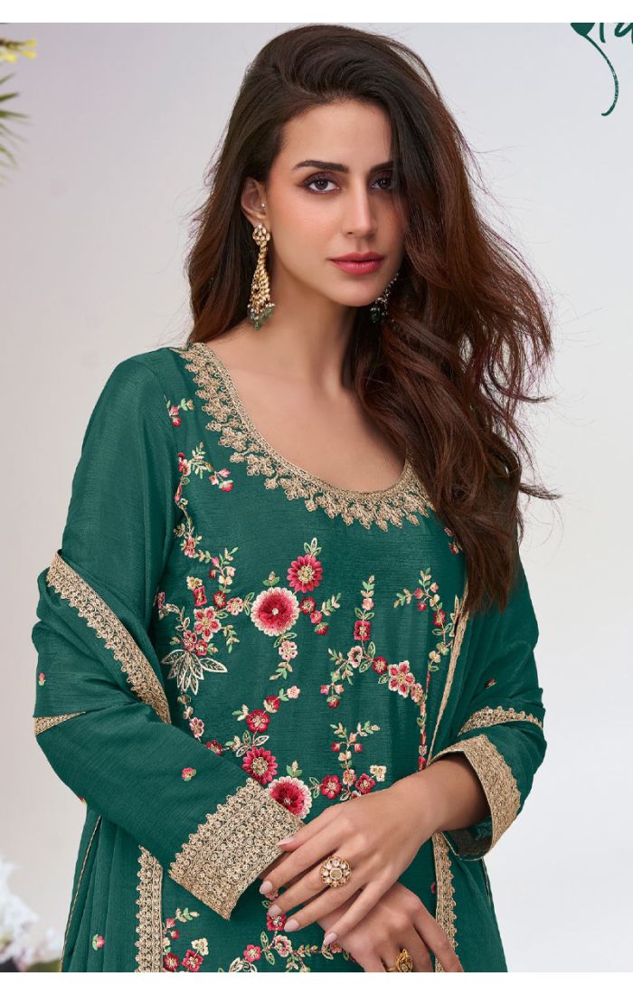 Close-up of green georgette suit showcasing intricate floral embroidery and lace-detailed scoop neckline.