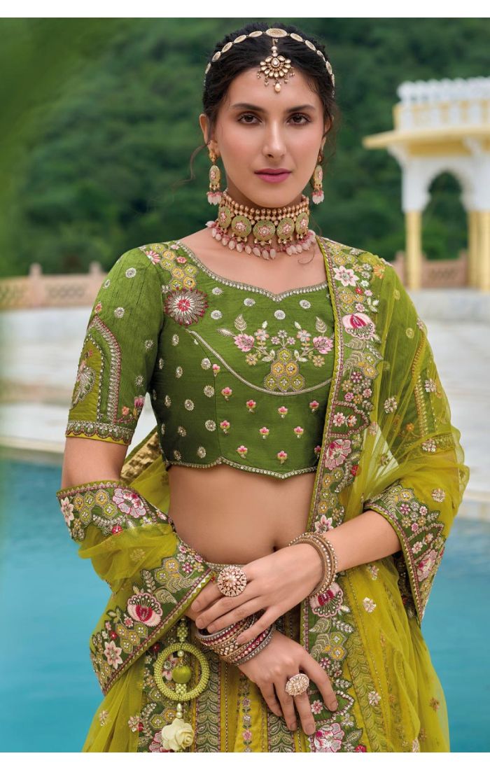 Model wearing a green floral embroidered lehenga choli, styled with traditional jewelry and light makeup, perfect for Haldi and festive occasions.