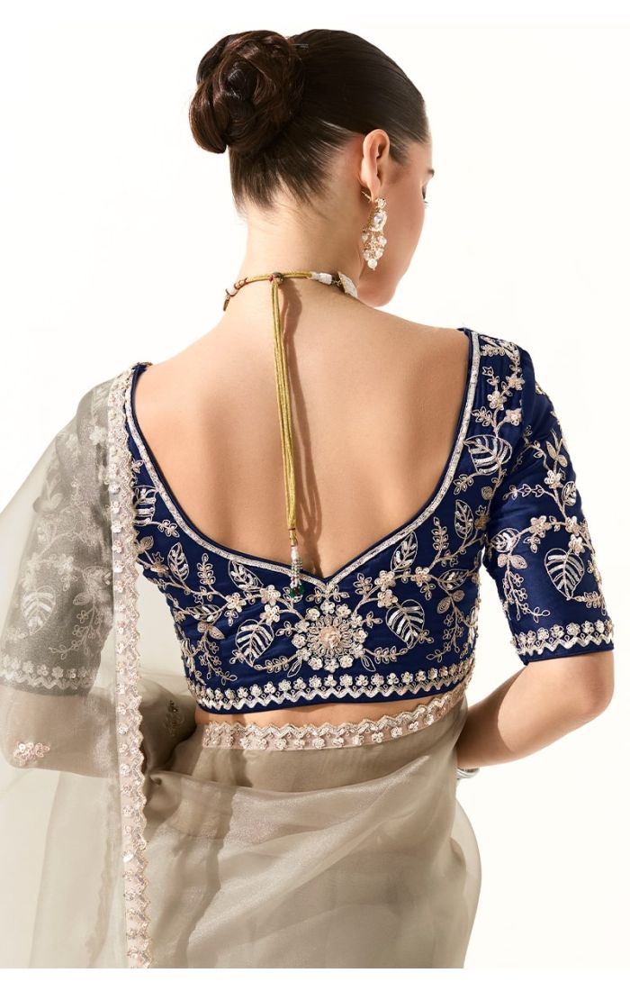 Back design of embroidered navy blouse paired with grey organza saree