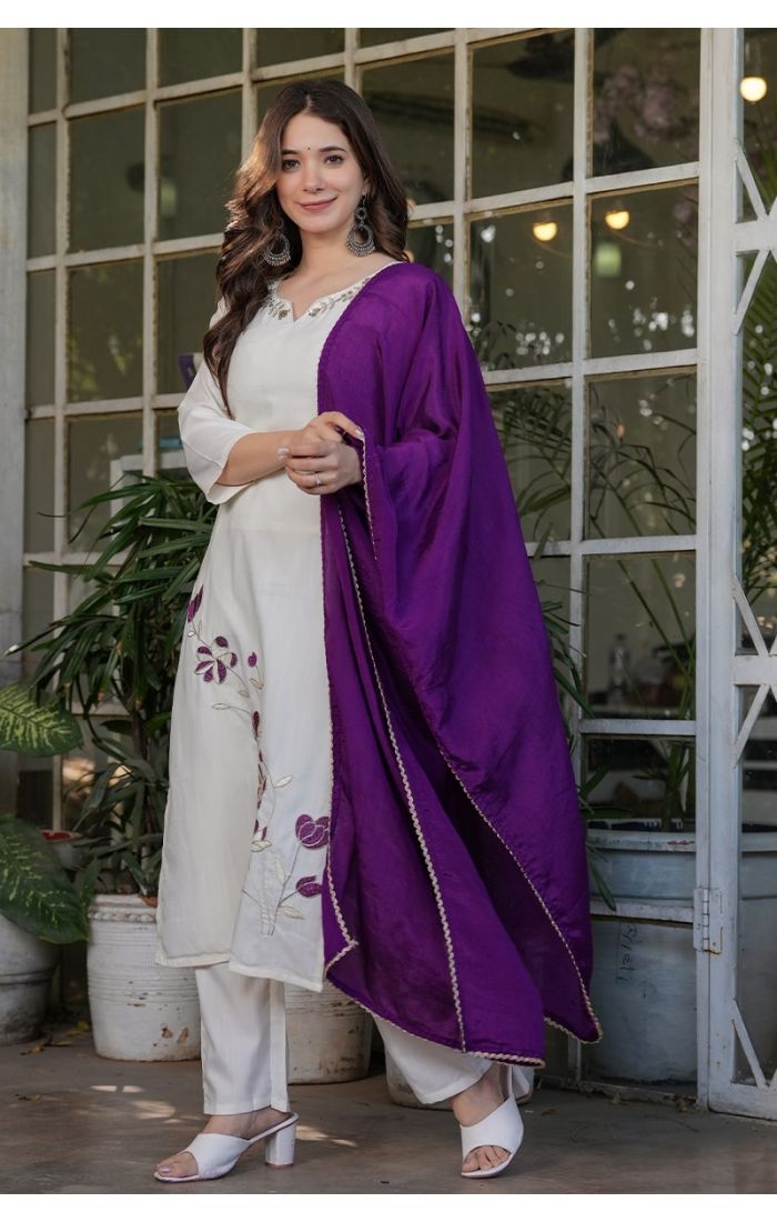 Off-white embroidered kurta pant set with a contrasting purple dupatta, perfect for festive and wedding occasions.