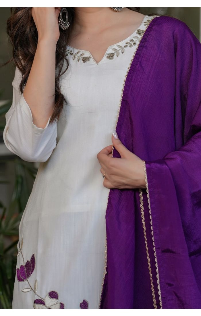 Off-white embroidered kurta pant set with a contrasting purple dupatta, perfect for festive and wedding occasions.