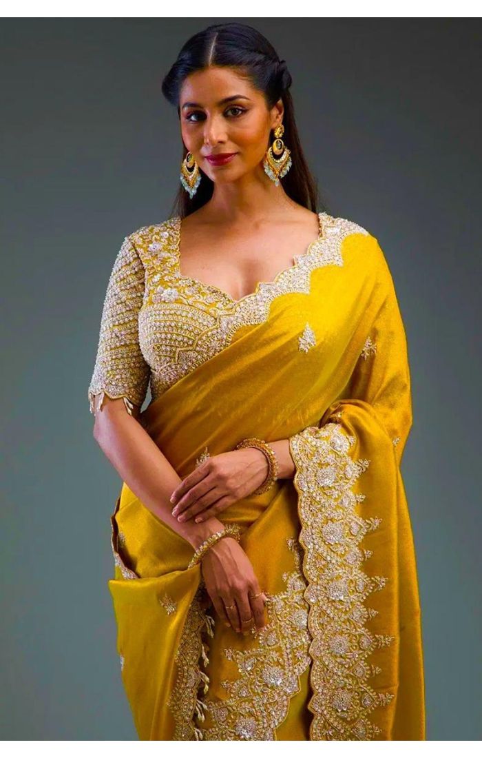 Close-up of embroidered blouse and saree pallu lace – mustard color
