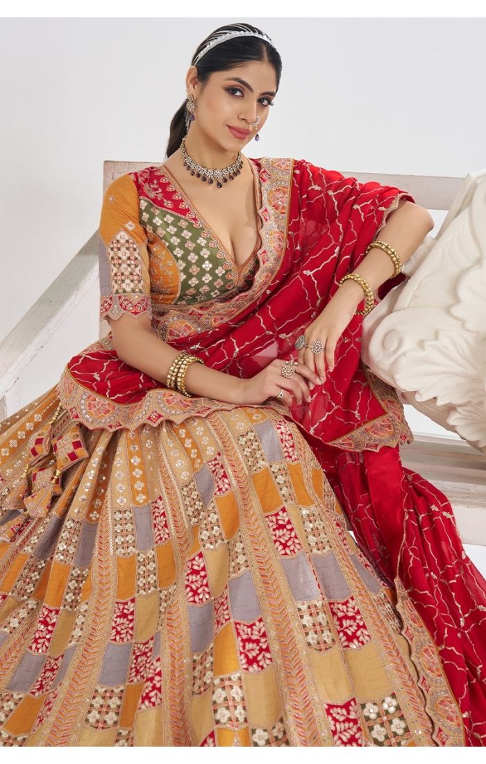 Sitting pose in mustard sequin lehenga with red dupatta – bridal festive look