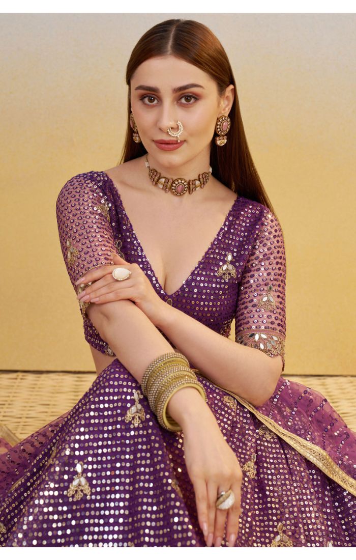 Detailed shot of purple V-neck blouse with sequin embroidery and sheer dupatta, statement bridal or festive fashion.