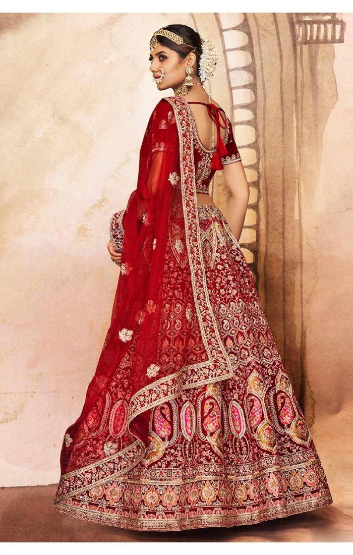 Flared skirt and rich border of red velvet bridal lehenga with paisley and floral embroidery, luxury bridal couture.