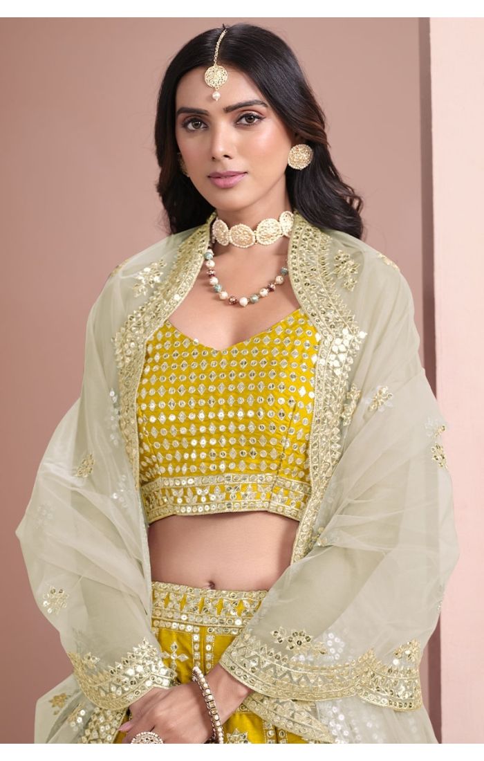 Regal Yellow Mirror Work Lehenga Choli with sleeveless blouse and net dupatta, perfect for weddings and festive occasions