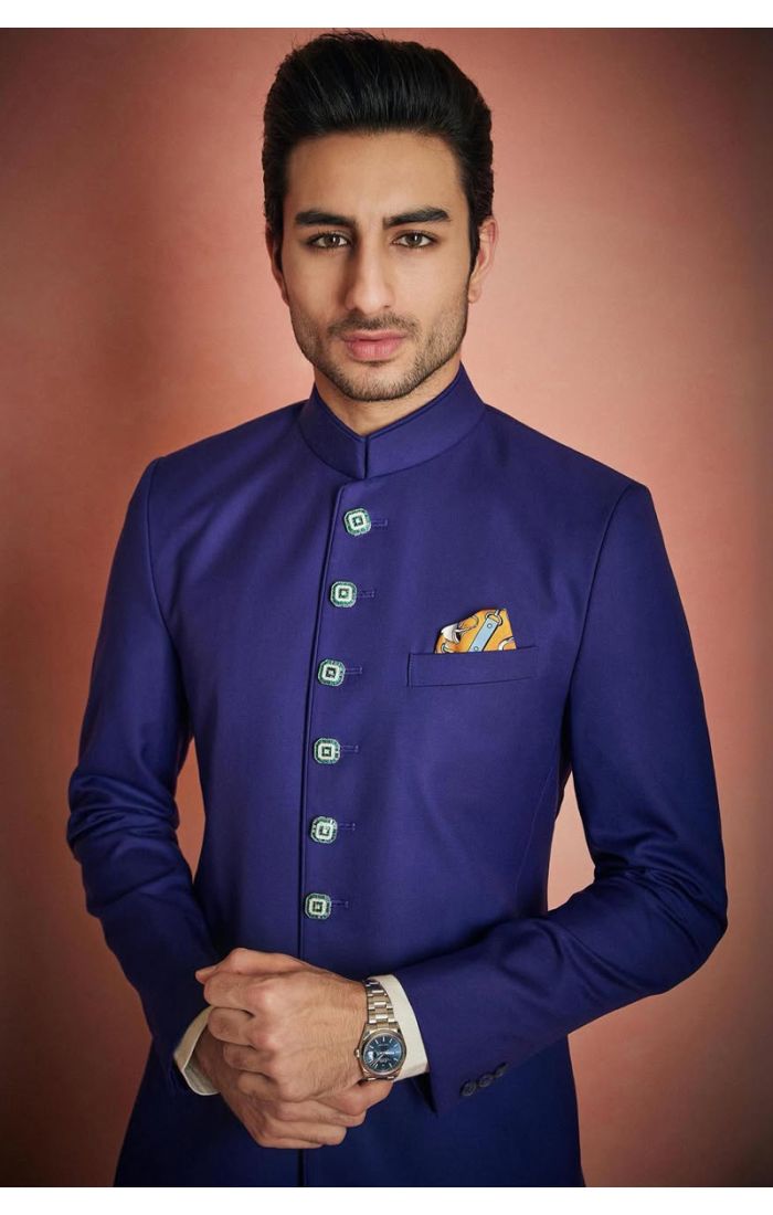 Men’s royal blue Indo-Western sherwani with silver-tone buttons, mandarin collar, and white pants, perfect for weddings and festive occasions.