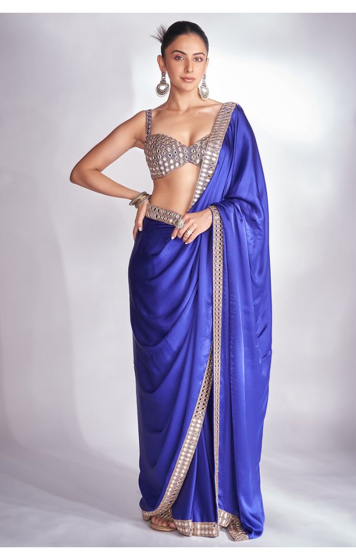 A stunning royal blue satin saree paired with an intricately embellished blouse, ideal for weddings and festive celebrations, available at Appelle Fashion.