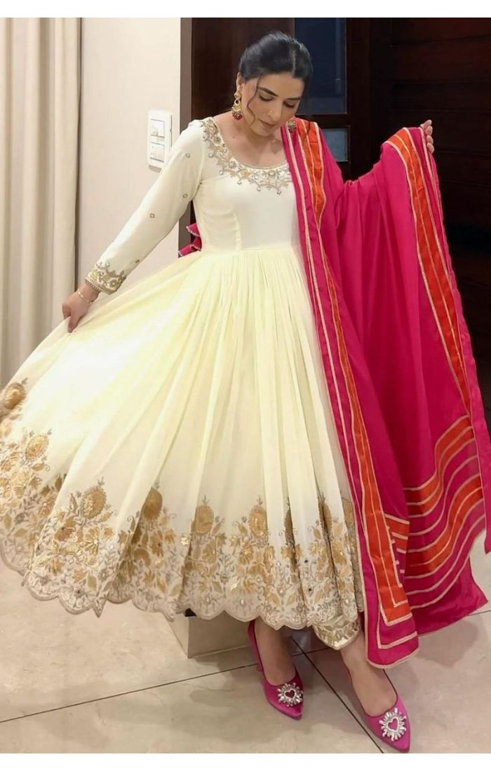 Elegant white georgette gown suit with golden embroidery and pink dupatta – perfect for weddings, parties, and festive occasions.