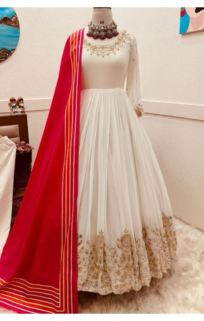 Elegant white georgette gown suit with golden embroidery and pink dupatta – perfect for weddings, parties, and festive occasions.