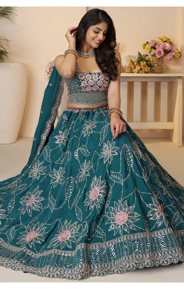 Sitting pose of model in blue floral lehenga for wedding wear