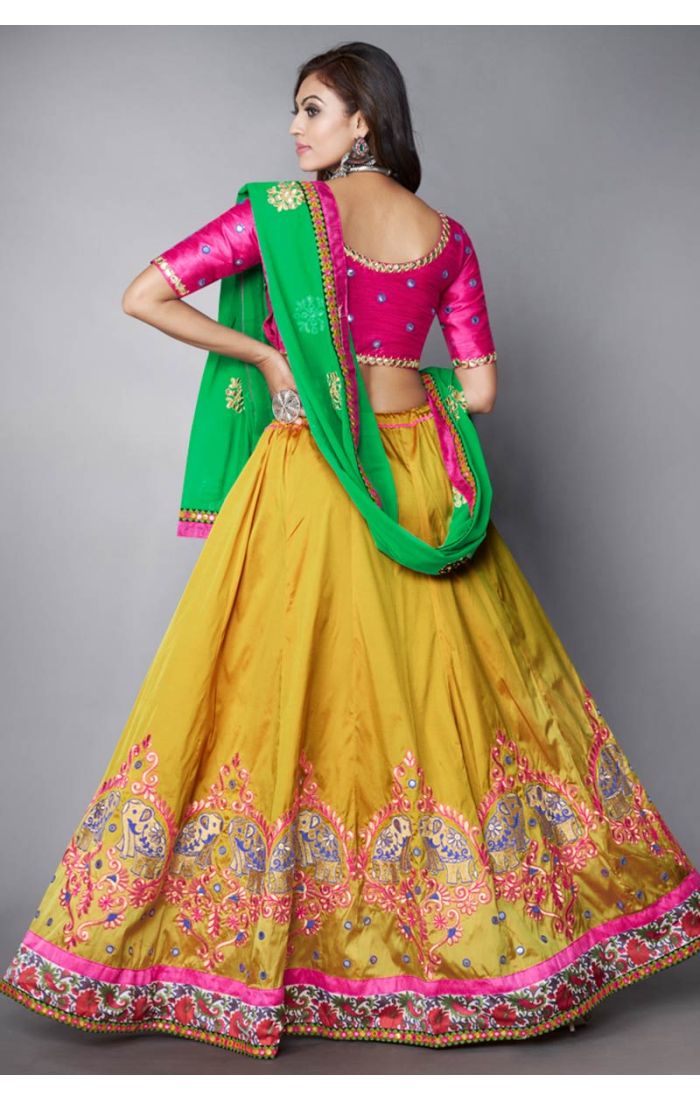 Flared yellow lehenga skirt with intricate elephant embroidery and mirror border design, traditional garba and dandiya wear.