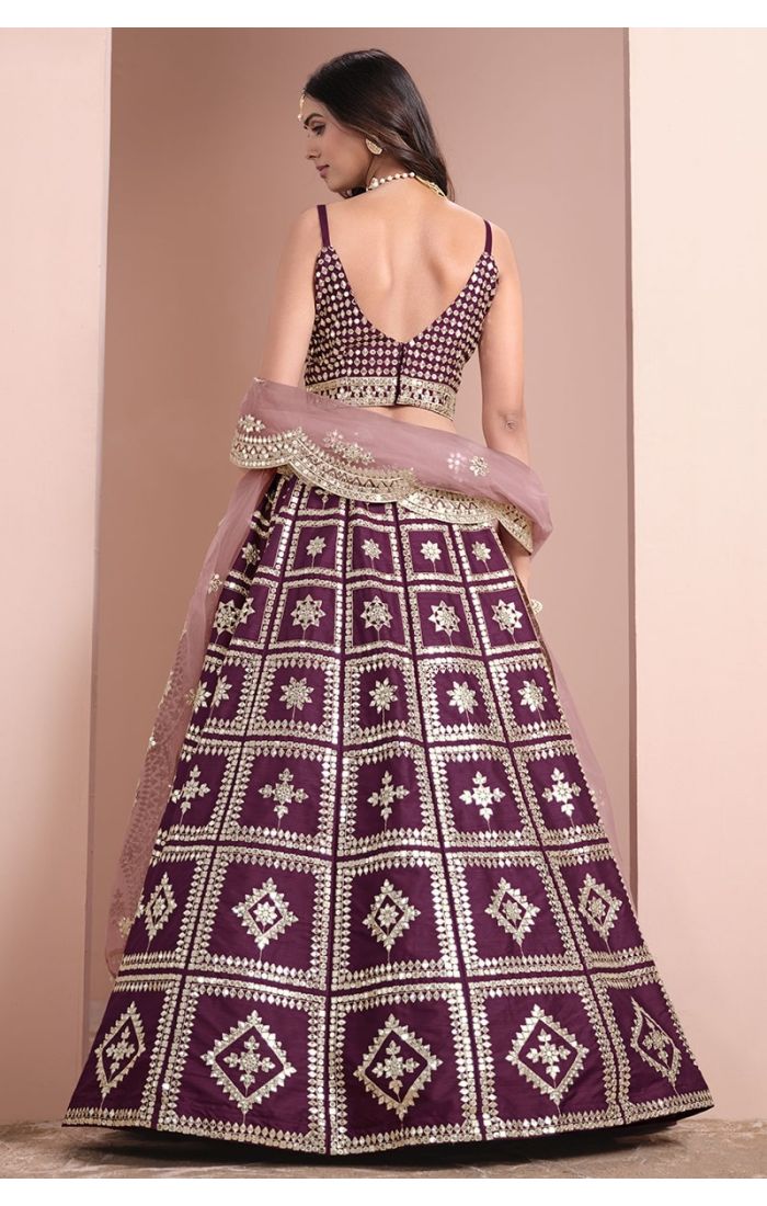 Wine-colored mirror work silk lehenga choli with net dupatta – perfect for weddings and festive occasions.