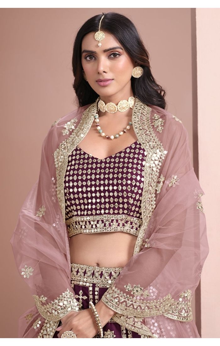 Wine-colored mirror work silk lehenga choli with net dupatta – perfect for weddings and festive occasions.